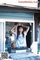 A woman standing in front of a stove in a kitchen.