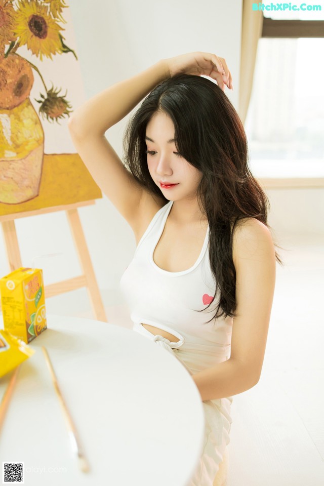 A woman sitting at a table with a box of juice.